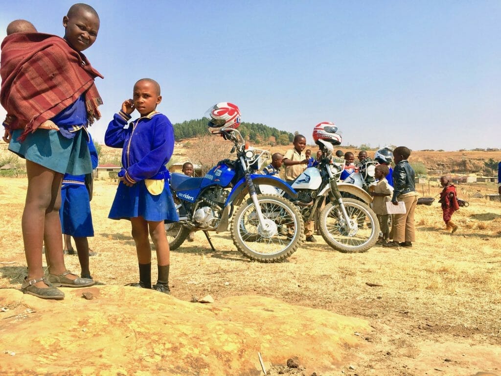 Lesotho, schoolgirls standing by motorcycles