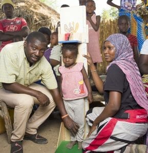 Community health worker charting children's growth.