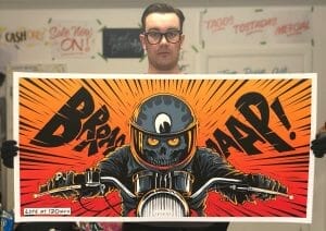 Ryan holding one of his artworks, showing his unique style